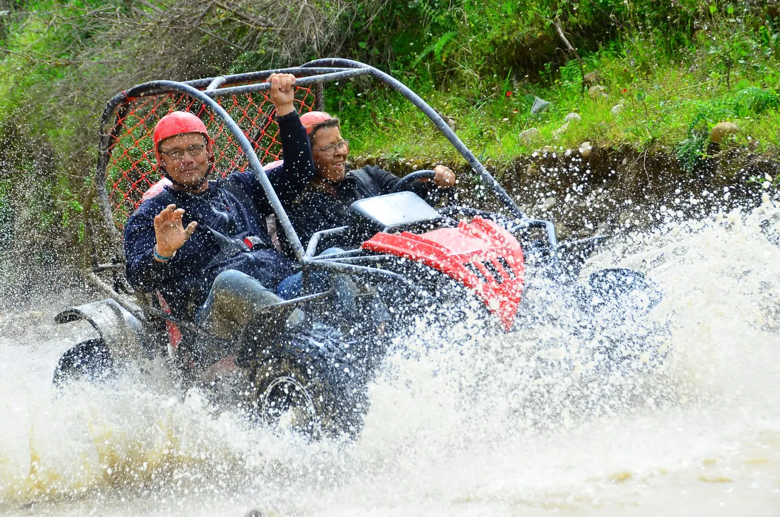 Two-seater buggy bursting through a water crossing on the Belek buggy safari