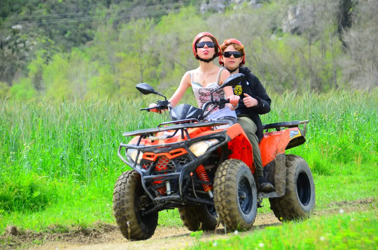 Couple riding a quad past open meadows on the Belek off-road trail