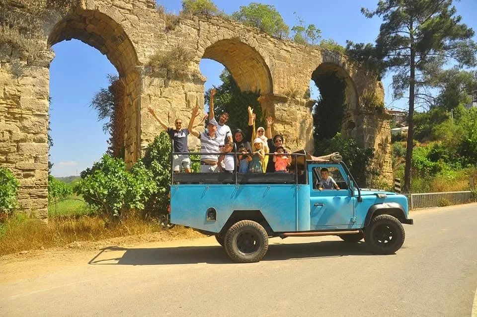 Jeep safari vehicle on the road beside the Roman aqueducts