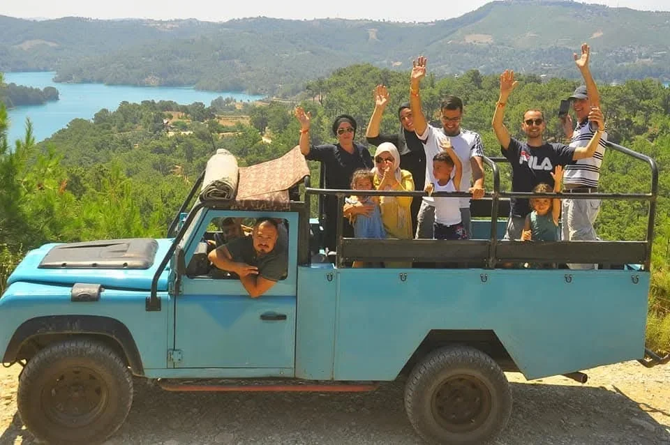 Open-top 4x4 jeep with guests at the viewpoint above Green Lake